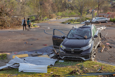 A car struck by a utility pole sits at the intersection of Breckenridge Drive and Shackleford Road in west Little Rock after a tornado plowed through the area Friday afternoon, March 31, 2023. (John Sykes/Arkansas Advocate)