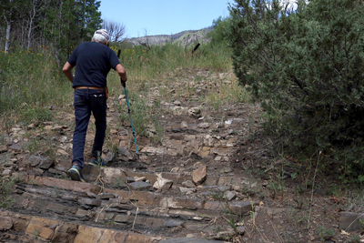 Naranjo walks up a washed-out road on his property.