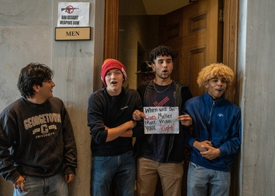 Three teenage boys with locked arms stand in front of the men&amp;#039;s room outside the Tennessee House of Representatives chamber. (Photo: John Partipilo)
