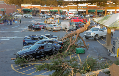 A tree lies across vehicles in the parking lot of the Colony West shopping center off Little Rock's Rodney Parham Road on Friday afternoon, March 31, 2023, after a tornado damaged hundreds of homes and businesses. (John Sykes/Arkansas Advocate)